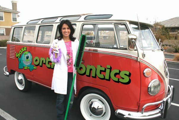 Dr. Saxe holding giant toothbrush standing next to a van.