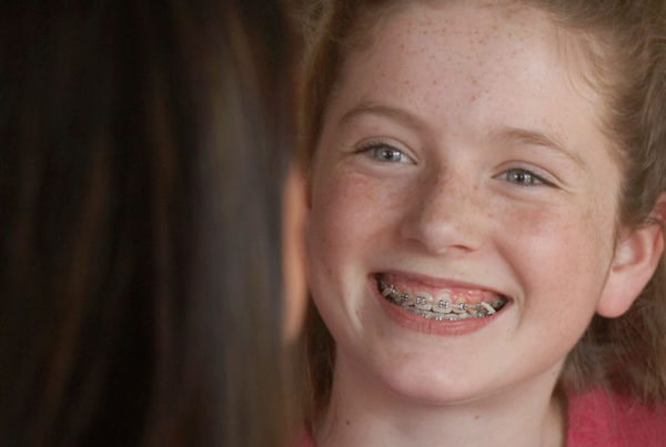 Smiling girl wearing rubber bands with braces