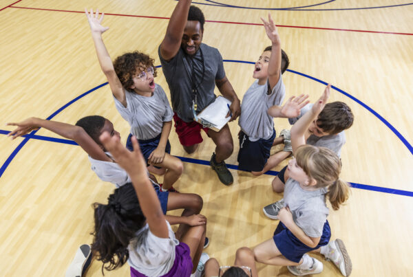 Coach and group of students in school gym, team cheer